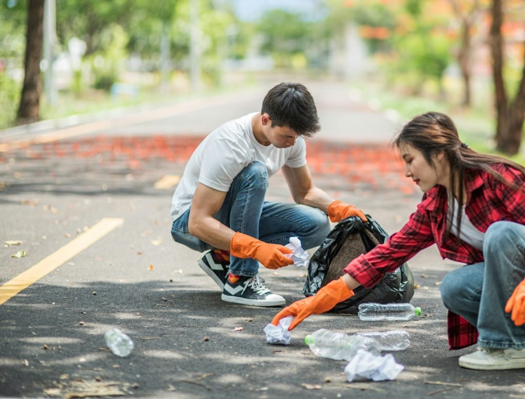Men and women help each other to collect garbage.