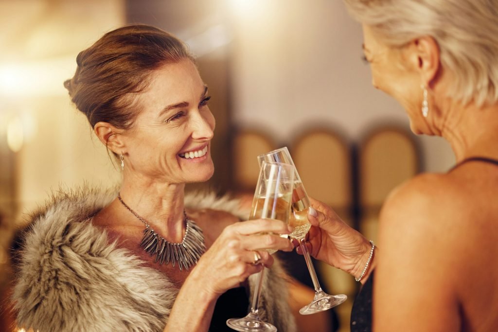 Success, women or toast in a party for goals, winning or new year at luxury social event. Mature, c